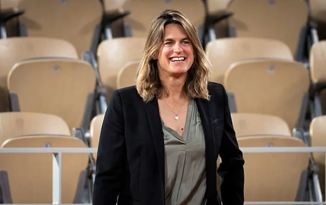 Roland Garros tournament director Amelie Mauresmo standing in the spectator seating area