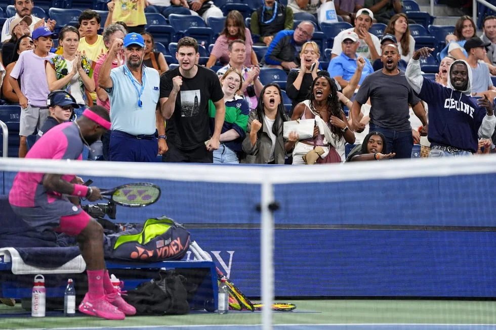 Frances Tiafoe beside the court with supporters cheering at the 2026 US Open